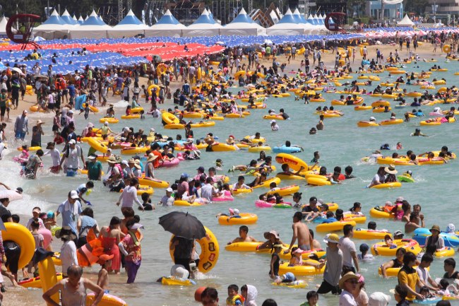 Holidaymakers crowd Haeundae beach earlier this month. (Yonhap News)