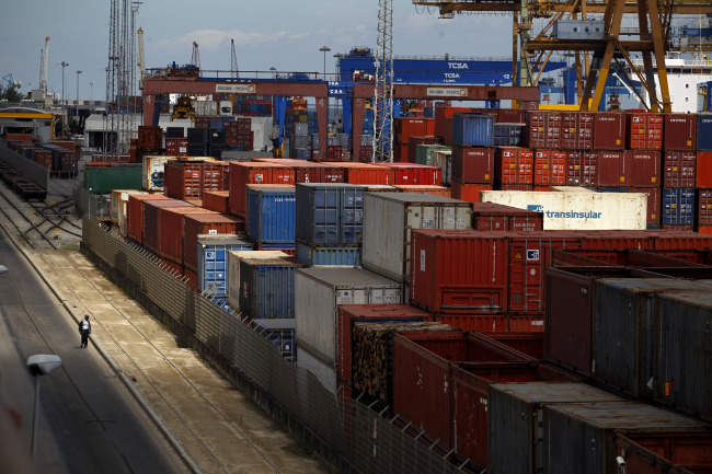 A man walks near containers at the port in Lisbon on Tuesday. (AP-Yonhap News)