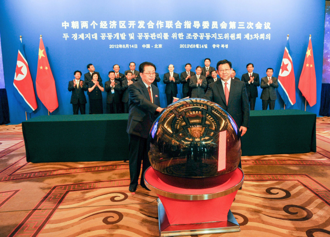 Jang Song-thaek (left) North Korea’s vice chairman of the powerful National Defense Commission, and Chinese Minister of Commerce Chen Deming attend the third meeting of the joint steering committee for developing and managing the special economic zones in North Korea, in Beijing on Tuesday. (Xinhua News)