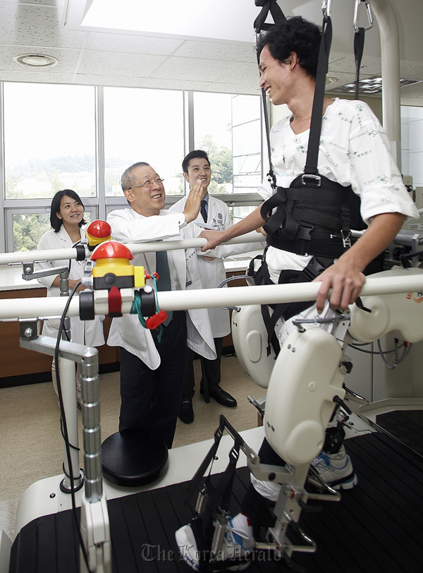 Doctors at Yonsei University’s Severance Hospital watch Truong Vinh Thuan receive robot-assisted gait training during his rehabilitation. (Kumho Tire)