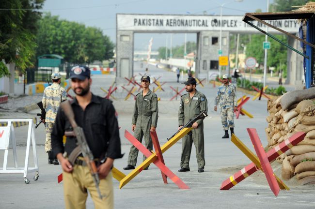 Pakistani Air Force personnel cordon the main entrance of the air force base following an attack in Kamra on Thursday. (AFP-Yonhap News)