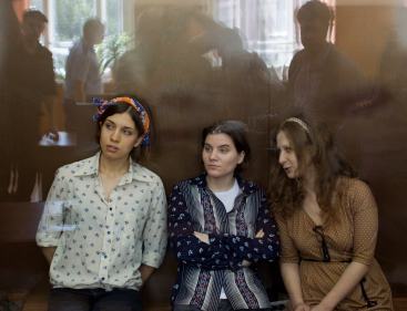 Pussy Riot members, from left, Nadezhda Tolokonnikova, Yekaterina Samutsevich and Maria Alekhina sit in a glass cage at a court room in Moscow, Russia on Aug. 3, 2012. (AP-Yonhap News)