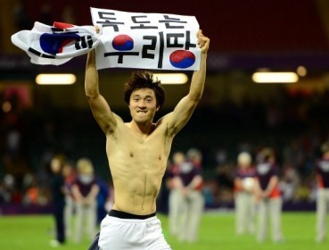 South Korean soccer player Park Jong-woo carries a sign given by a fan that reads “Dokdo Is Our Territory,” after winning the bronze medal match against Japan at the 2012 London Olympics on Friday. ( Ahn Hoon/The Korea Herald)