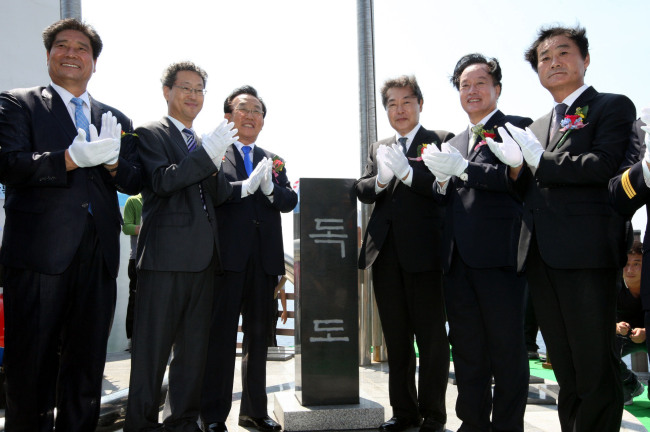 Public Administration and Security Minister Maeng Hyung-kyu (third from right) and other participants on Sunday celebrate the erection of a monument on Dokdo. The 1.2-meter-tall monument is inscribed in Korean with “Dokdo” on its front and the “Republic of Korea” on the back. (Yonhap News)