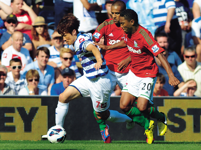 Queens Park Rangers’ Park Ji-sung seeks separation from Swansea City defenders on Saturday. (Penta-Yonhap News)