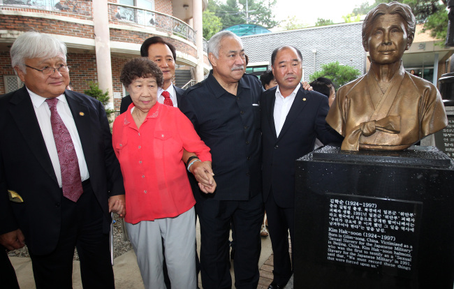 U.S. Representatives Michael Honda (left) and Eni Faleomavaega (second from right) look at the statue of late Kim Hak-soon, a victim of Japan’s sexual enslavement of women during World War II, at a home for Korean former sex slaves located in Gwangju on Monday. (Yonhap News)