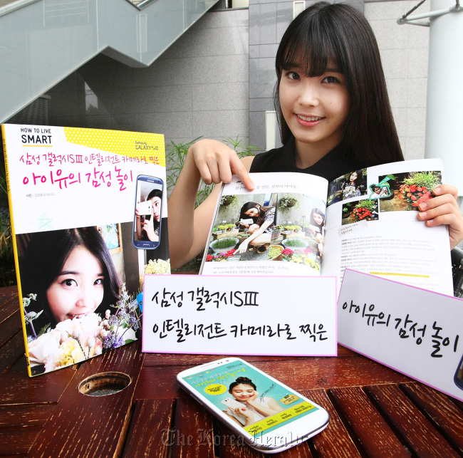 IU poses with her book. ( Samsung Electronics)
