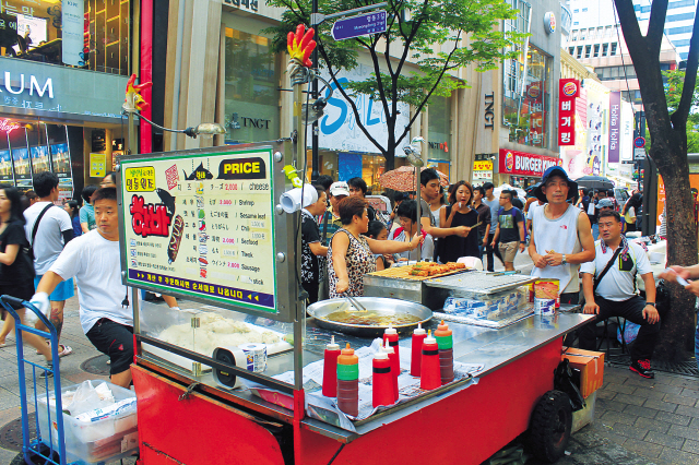 A food cart selling king-size fish cakes uses a cauldron of hot oil to deep-fry them. (Lee Hyun-jae/The Korea Herald)