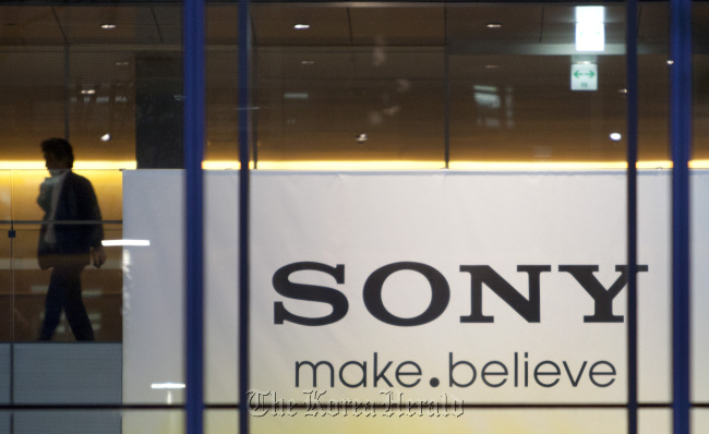 A man walks near a banner bearing the Sony Corp. logo at the company’s headquarters in Tokyo. (Bloomberg)