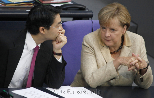 Germany’s Economy Minister Philipp Roesler (left) speaks with German Chancellor Angela Merkel in the lower-house of the German Parliament in Berlin on Sept. 29. (Bloomberg)