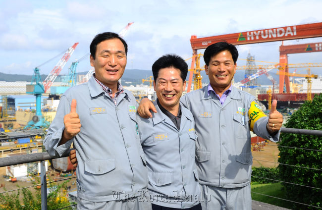 Hyundai Heavy Industries workers (from left) Kim Geum-man, Heu Tae-young and Kim Choon-jin pose at their workplace after winning the 2012 Korea Master Artisan’s Award. (HHI)