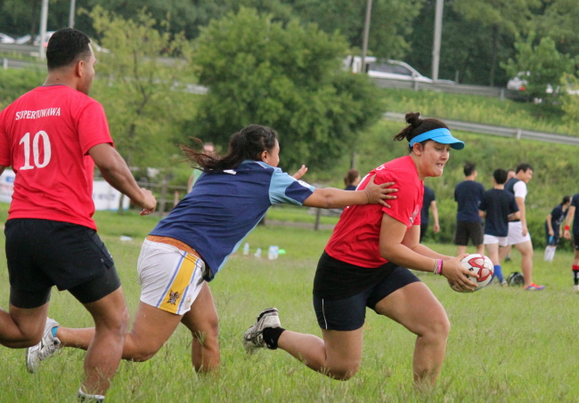 Pauline Stokes, of the Island Stylez touch team seeks to evade Tara Tasi’s tackle. (Erik Sorenson)