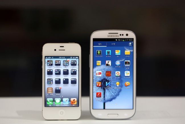 An Apple Inc. iPhone 4S smartphone (left) and a Samsung Electronics Co. Galaxy S III smartphone are arranged for a photograph in Seoul. (Bloomberg)