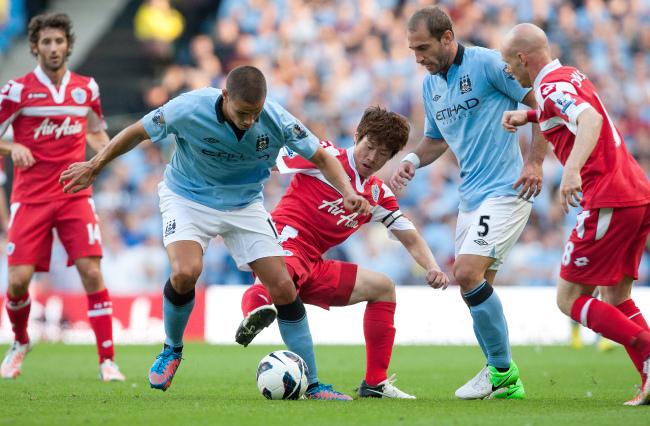 Park Ji-sung (center) challenges Jack Rodwell of Manchester City at the Etihad Stadium in Manchester, England, Saturday. (PENTA PRESS-Yonhap News)