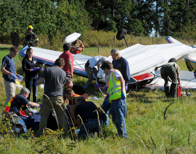 Emergency personnel attend to pilot Richard Bach after Bach’s plane crashed in a field, in Friday Harbor, Washington, Friday. (AP-Yonhap News)