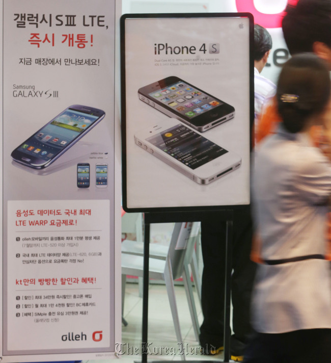 Signs advertise Samsung’s Galaxy S3 and Apple’s iPhone 4S at a store in COEX in southern Seoul. (Yonhap News)