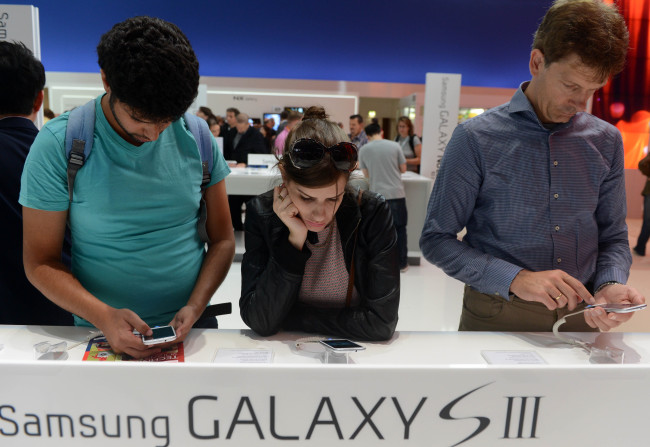 Visitors try out the Samsung Galaxy S3 smartphones at the Samsung pavilion at the IFA consumer electronics fair in Berlin,on Friday. (Xinhua-Yonhap News)