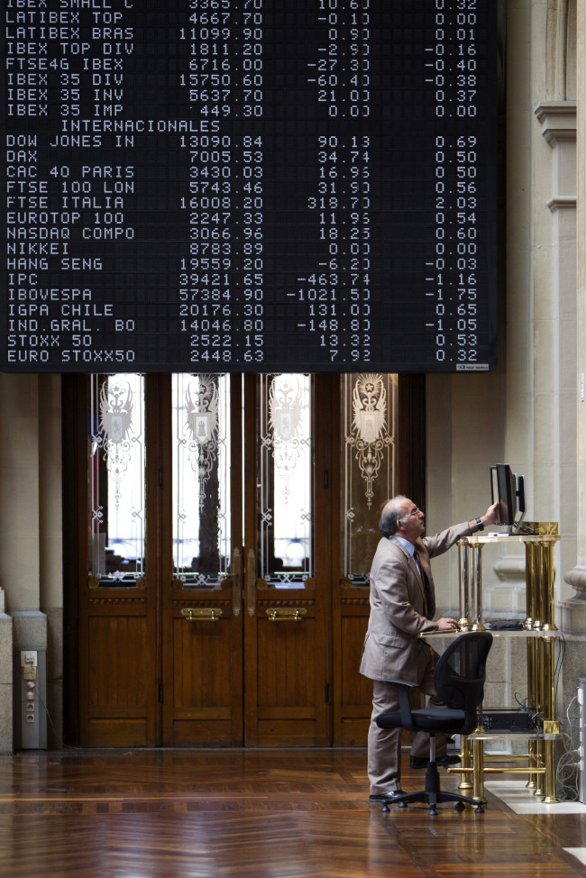 A visitor checks an electronic screen for stock price information inside the Madrid stock exchange, or Bolsas y Mercados, in Madrid. (Bloomberg)