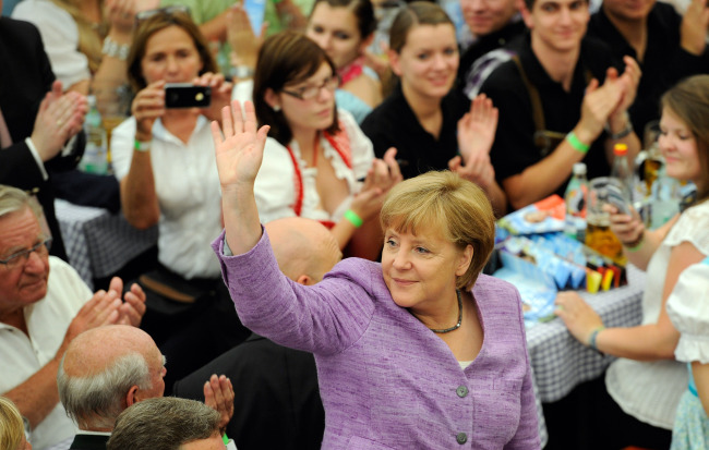 German Chancellor Angela Merkel waves to members of the public in a beer tent during a fair in Abensberg, Germany, Monday. (Bloomberg)