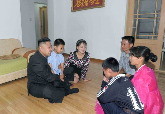 Kim Jong-un (left) and his wife Ri Sol-ju (third from left) visit a home of a working-class family in a new town district in Pyongyang in this undated image disclosed by the North’s official Korean Central News Agency on Wednesday. (Yonhap News)