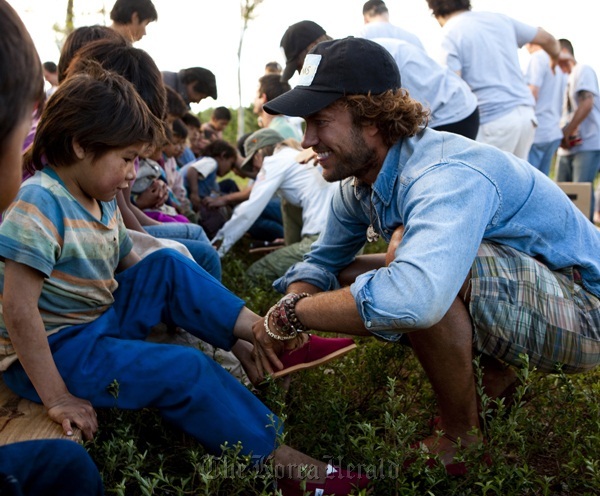 Blake Mycoskie (right), founder and chief shoe giver of Toms Shoes, delivers shoes to kids in Argentina in 2010. (Toms Shoes)