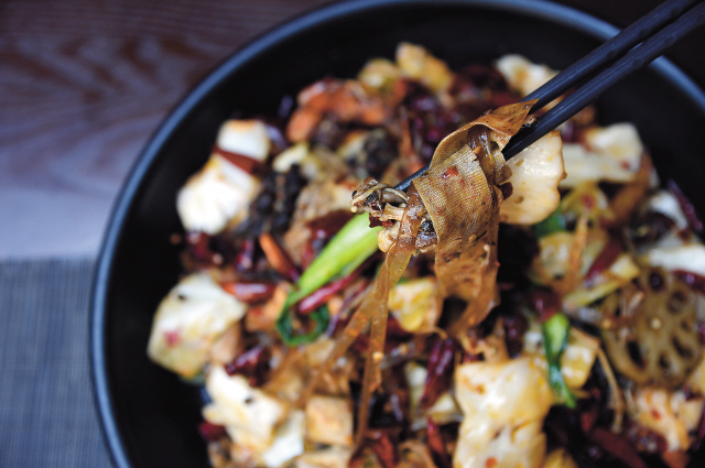 Mala xiangguo — a Sichuanese dish that is popular in Beijing — combines chilies, peppercorns, medicinal herbs, long strips of bean curd skin, chewy noodles, vegetables and other ingredients for a fiery, fragrant experience. (Ahn Hoon/The Korea Herald)