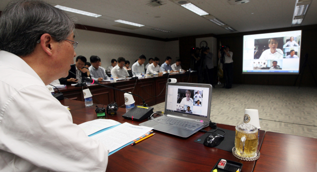 Officials of the Prime Minister’s Offices in Seoul and Sejong City hold a video conference Wednesday. (Yonhap News)