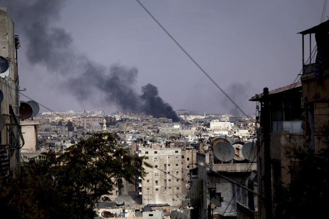 Black smoke rises over Aleppo, Syria, after airstrikes Tuesday. ( AP-Yonhap News)