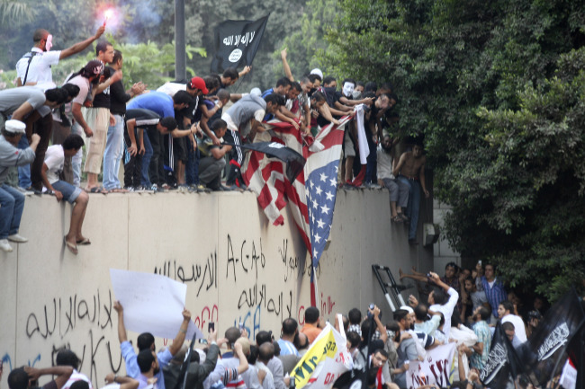 Protesters destroy an American flag pulled down from the U.S. Embassy in Cairo on Tuesday. (AP-Yonhap News)