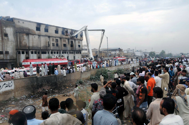 Pakistani firefighters conduct rescue operation at the garments factory in southern Pakistani port city of Karachi on Wednesday. (Xinhua-Yonhap News)