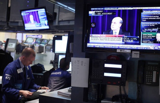 Traders work on the floor of the New York Stock Exchange as Fed Chairman Ben Bernanke speaks at a news conference on Thursday. (AFP-Yonhap News)