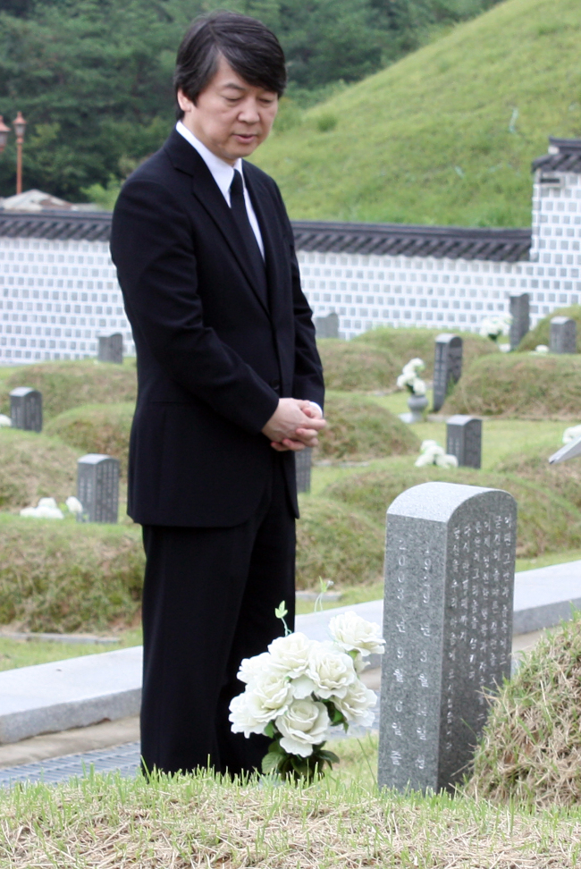 Professor Ahn Cheol-soo pays respect to a victim killed during the 1980 civil uprising at the May 18 National Cemetery in Gwangju on Friday. The photo was released by Ahn’s supporters.