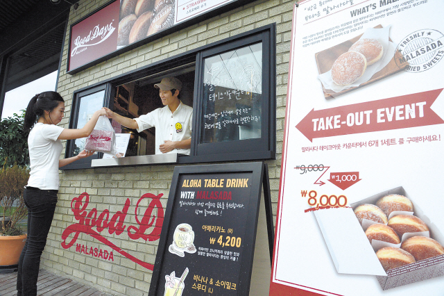 Patrons can get a fresh-out-of-the-fryer dozen to go at the Good Days Malasada take-out window. (Chung Hee-cho/The Korea Herald)