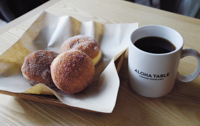 Aloha Table’s shop-in-shop Good Days Malasada serves up three variations of the Portuguese treat — plain sugar, strawberry sugar and cinnamon sugar. Doughnuts and coffee are a classic combination and at Aloha Table, the brew is Kona. (Chung Hee-cho/The Korea Herald)