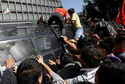 Chinese men scale a barricade in an attempt to enter the Japanese embassy in Beijing, China, Saturday. (AP-Yonhap)