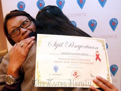 Norazatulshima Nordin hugs a fellow participant after completing a Malaysian AIDS Council program on living with HIV/AIDS. (The Star)