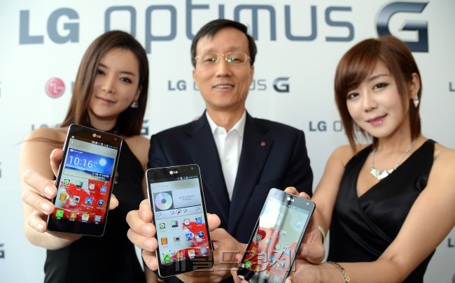 Park Jong-seok (center), mobile chief at LG Electronics, and models pose with LG’s new flagship smartphone Optimus G at a product launch in Seoul on Tuesday. (Ahn Hoon/The Korea Herald)