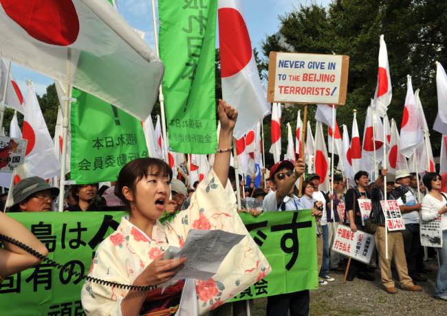 Right wing acrivists hold national flags and placards to protest against China in Tokyo on Saturday. (AFP-Yonhap News)