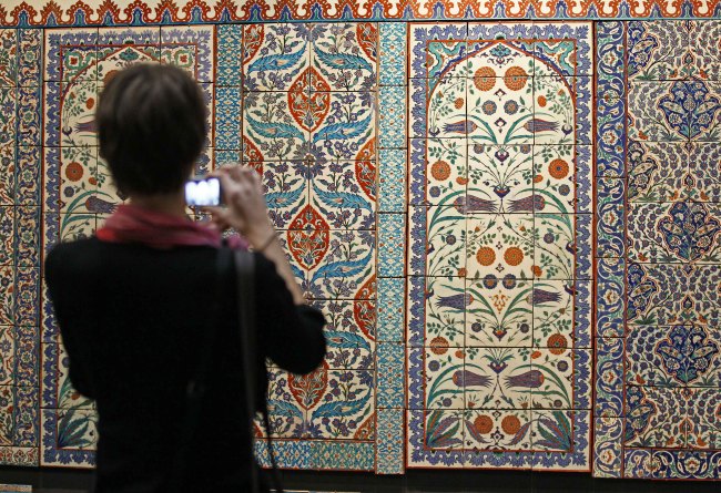 A member of the media takes snapshots of a ceramic tile wall displayed at the Louvre Museum in Paris, Sept. 20. ( AP-Yonhap News)