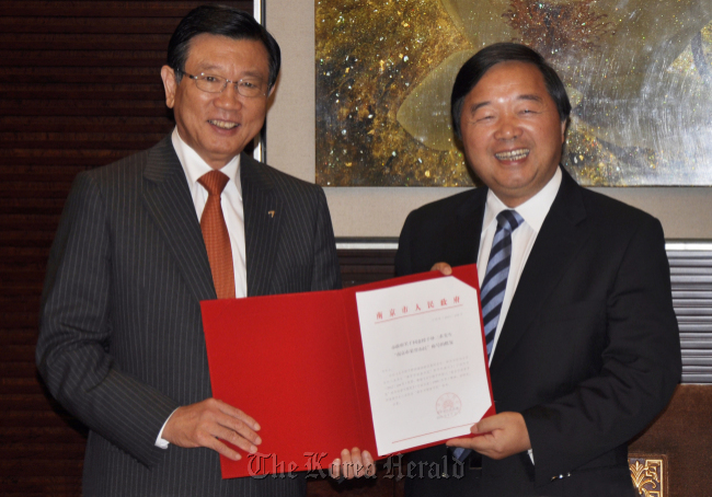 Kumho Asia Group chairman Park Sam-koo (left) poses with a Nanjing official after receiving the certificate of honorary citizen of the Chinese city of Nanjing on Monday. (Kumho Asiana)