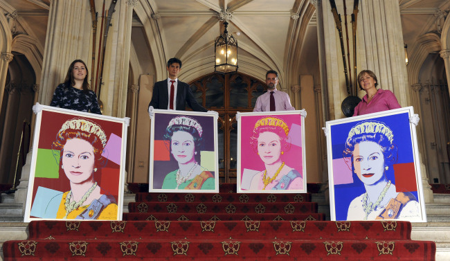 From left: Exhibition curator Lauren Porte, Royal Collection staff Allan Chinn, Martin Clayton, and Kate Stone stand with four Andy Warhol portraits of Queen Elizabeth II in Windsor Castle, Windsor, England, on Monday. (AP-Yonhap News)