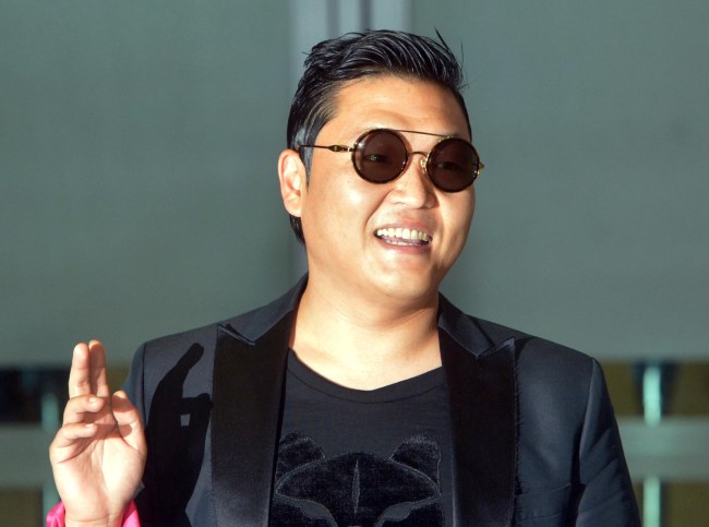 Psy waves his hand at Incheon International Airport on Tuesday morning. (Kim Myung-sub/The Korea Herald)