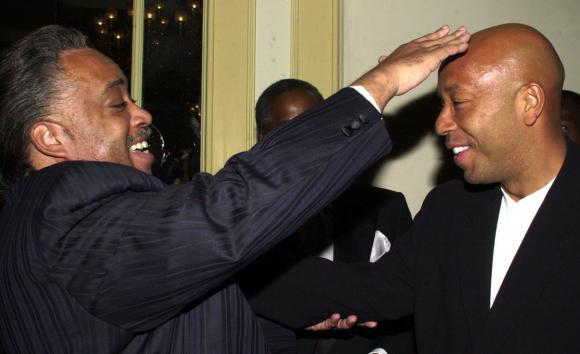 Political activist Al Sharpton jokes about hip hop mogul Russel Simmons bald head before the start of the National Action Network Keeper of the Dream Award ceremonies hosted by Sharpton April 5, 2001 in New York City. (UPI)