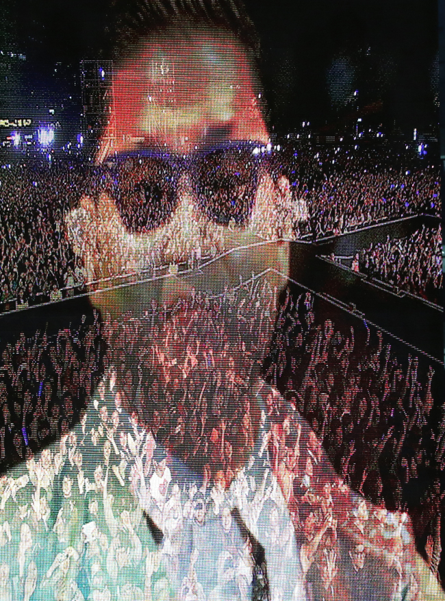 A screen shot of Psy’s “Seoul Style” concert in front of 80,000 screaming fans at the Seoul Plaza on Thursday night shows the singer’s face superimposed over a shot of the audience. (Yonhap News)