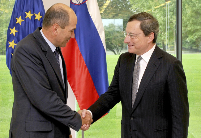 Slovenia’s Prime Minister Janez Jansa (left) shakes hands with ECB chief Mario Draghi on Thursday. ( AP-Yonhap News)