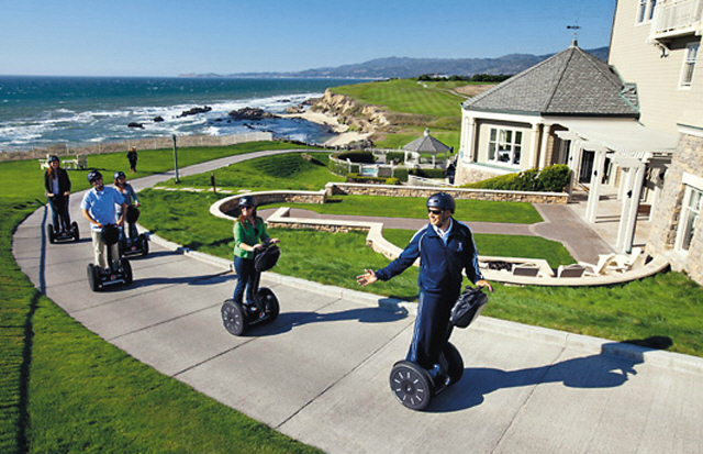 Ritz-Carlton Half-Monn Bay hotel recreational staff member lead a group of hotel guests on a Segway tour of the Coastal Trail in Half-Moon Bay, California on the Pacific Ocean with the hotel property on a nearby cliff. (Ritz-Carlton)