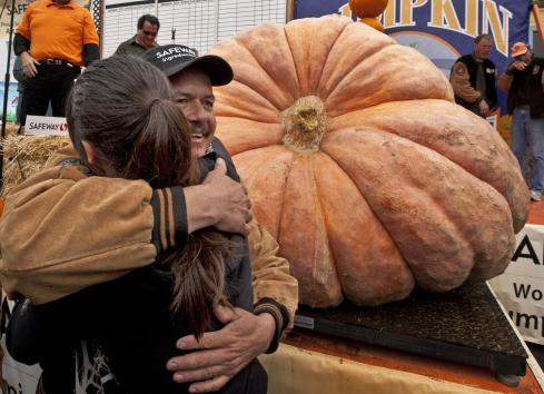 Leonardo Urena of Napa, CA hugs his daughter in front of his 1,704-pound pumpkin which won the 38th annual Pumpkin Weigh-off in Half Moon Bay, California on Oct. 10, 2011. The giantic gourd set a state record. (UPI)