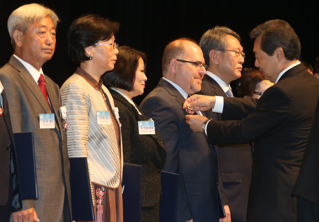 Professor S. Goksel Turkozu (fourth from left) from the University of Erciyes, Turkey, along with nine others, receives a Presidential Citation from Minister of Public Administration and Security Maeng Hyung-kyu on Tuesday. (Yohhap News)