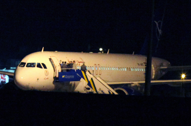 People gather atop the aircraft steps at a Syrian passenger plane that was forced by Turkish jets to land at Esenboga airport in Ankara on Wednesday. (AP-Yonhap News)