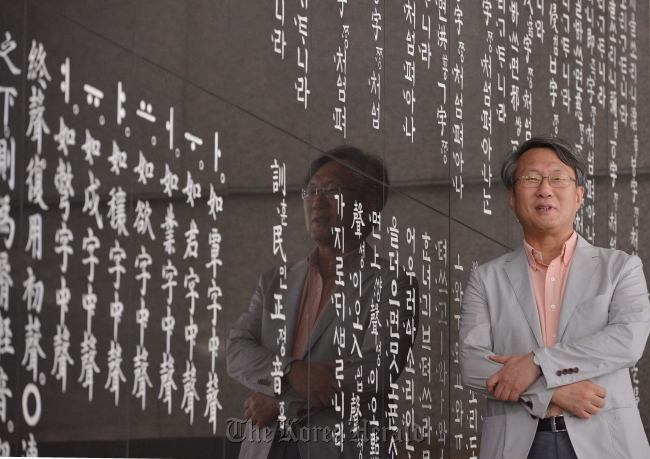 In this file photo Song Hyang-keun, chief of Sejong Hakdang Foundation, stands beside the wall engraved with texts from “Huminjeongeum,” King Sejong’s book introducing Hangeul, at the National Institute of the Korean Language in Banghwa-dong, Seoul. The institute was transformed into a foundation following a legal revision. (Lee Sang-sub/The Korea Herald)